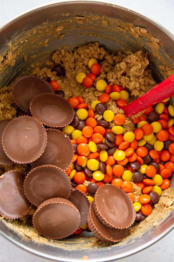 the peanut butter cups and reese's pieces being mixed into the dough.
