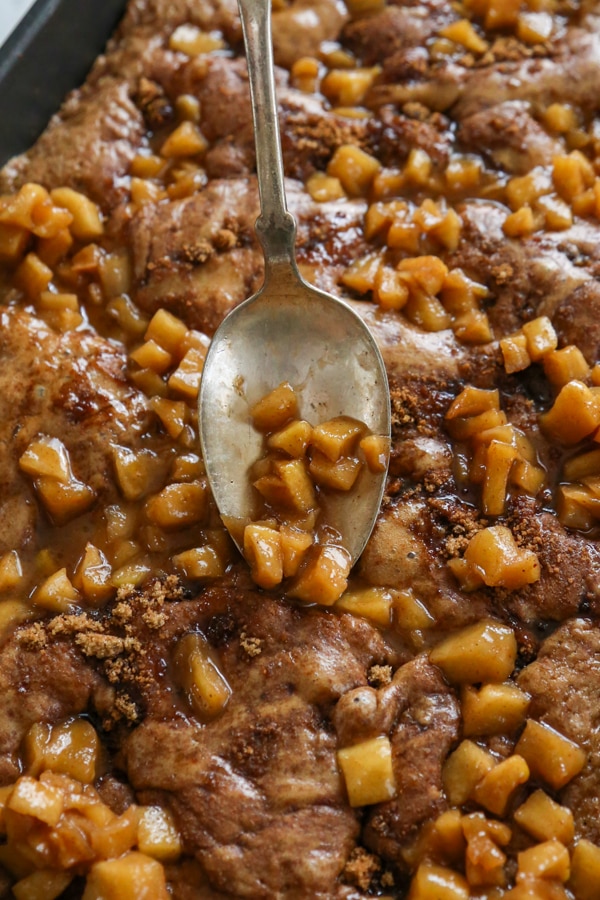 caramel apples being spooned over the top of the coffee cake.