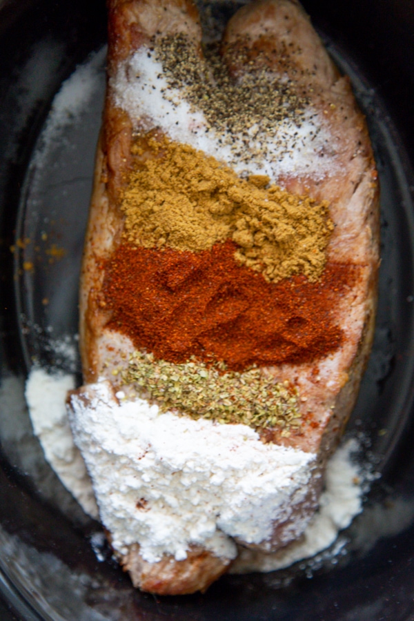 the seasonings on top of the pork tenderloin in the slow cooker.
