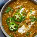 pork green chile in a bowl with garnishes.