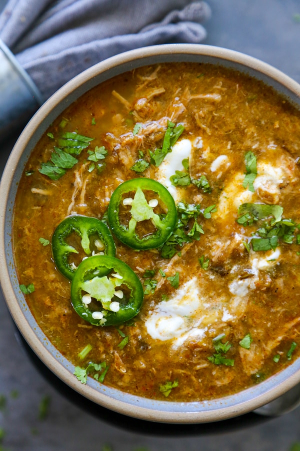 pork green chile in a bowl with garnishes.