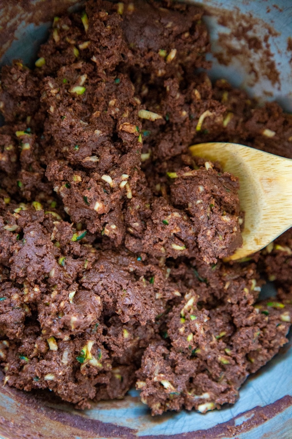 The brownie batter being mixed in a bowl.