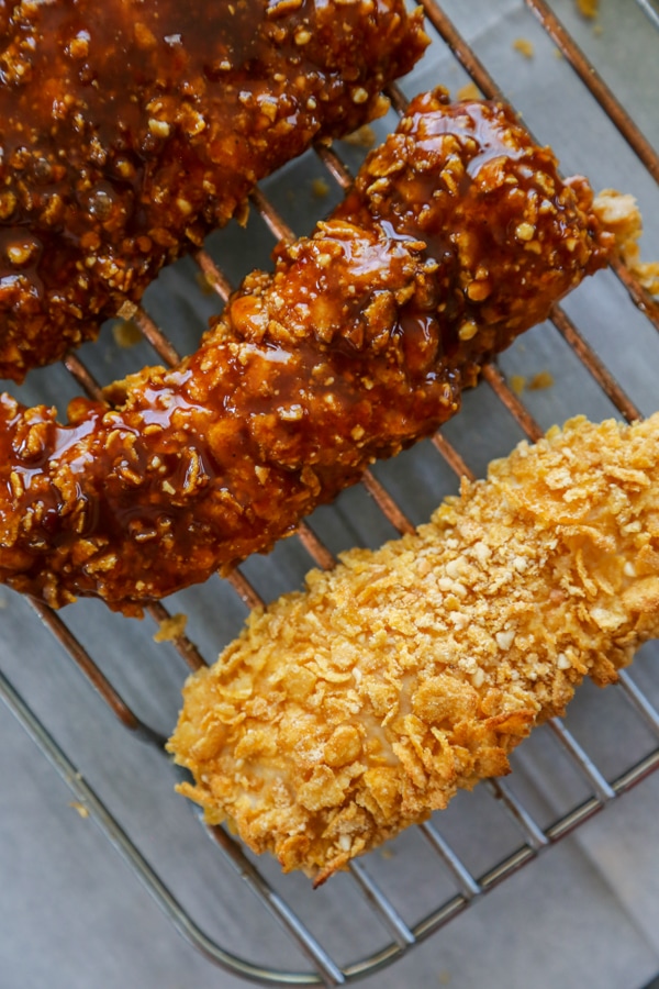 chicken coated in sauce and one plain piece on a baking rack.