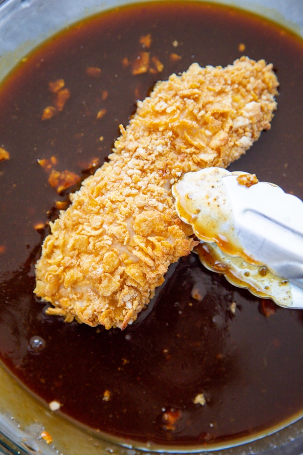 a crusted piece of chicken ready to dip in the sauce.