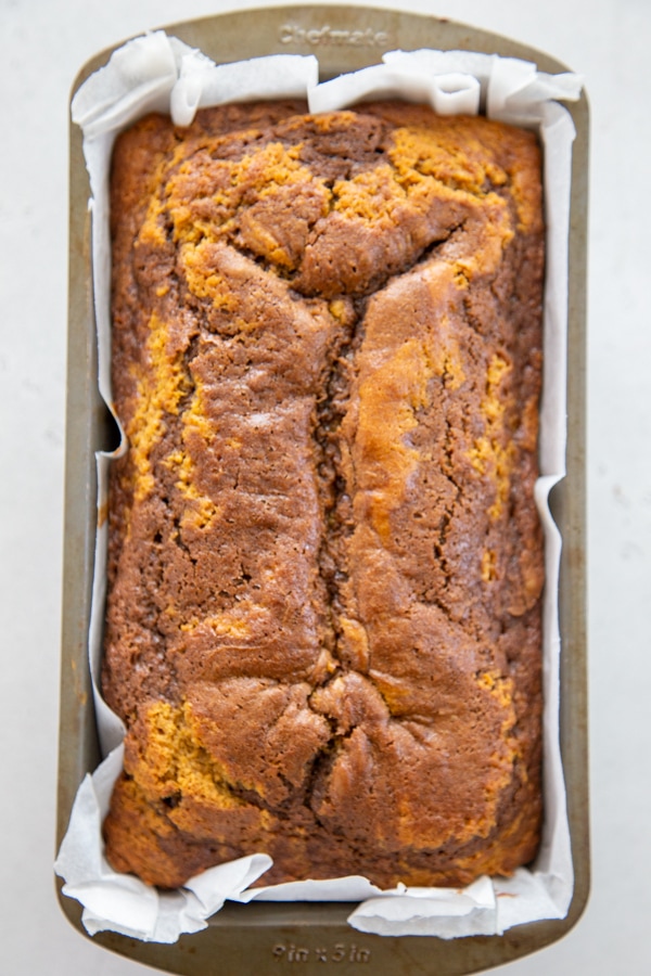 Pumpkin Nutella Swirl Bread takes pumpkin, chocolate, & hazelnut to a new level. Not only is it a beauty to look at, it's moist and full of fall flavors. the baked pumpkin bread in a pan.