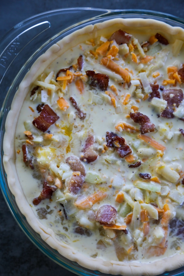 the ingredients for the quiche in the pan ready to be baked.