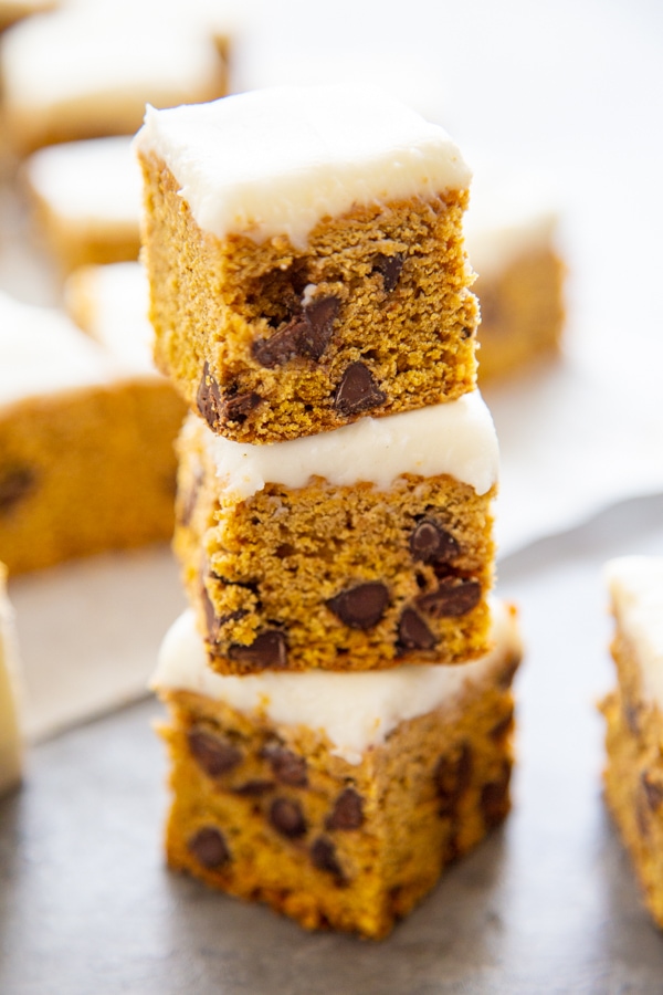 a stack of three frosted pumpkin bars.