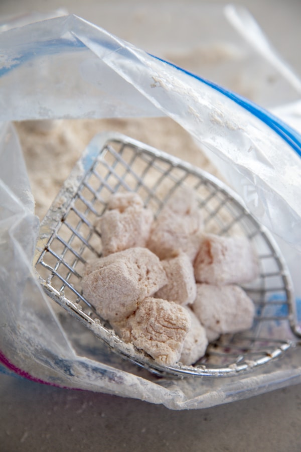 the chicken coated in the flour mixture.