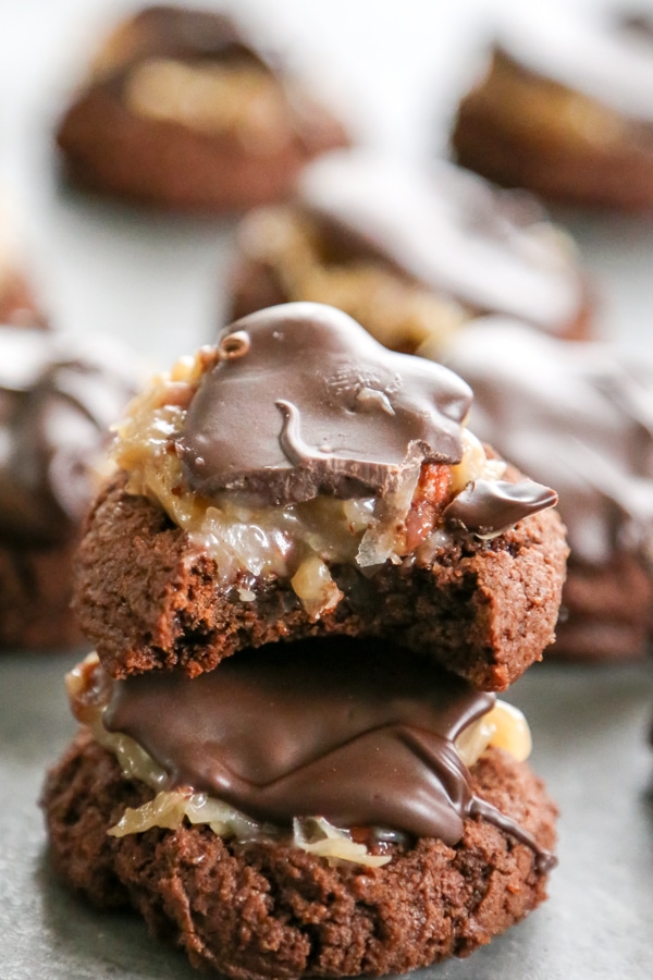 These Mini German Chocolate Thumbprint Cookies are fudgey-brownie like cookies topped with a chocolate drizzle, toasted coconut, and chopped pecans.