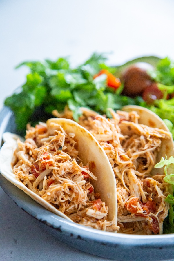 two chicken tacos on a plate.