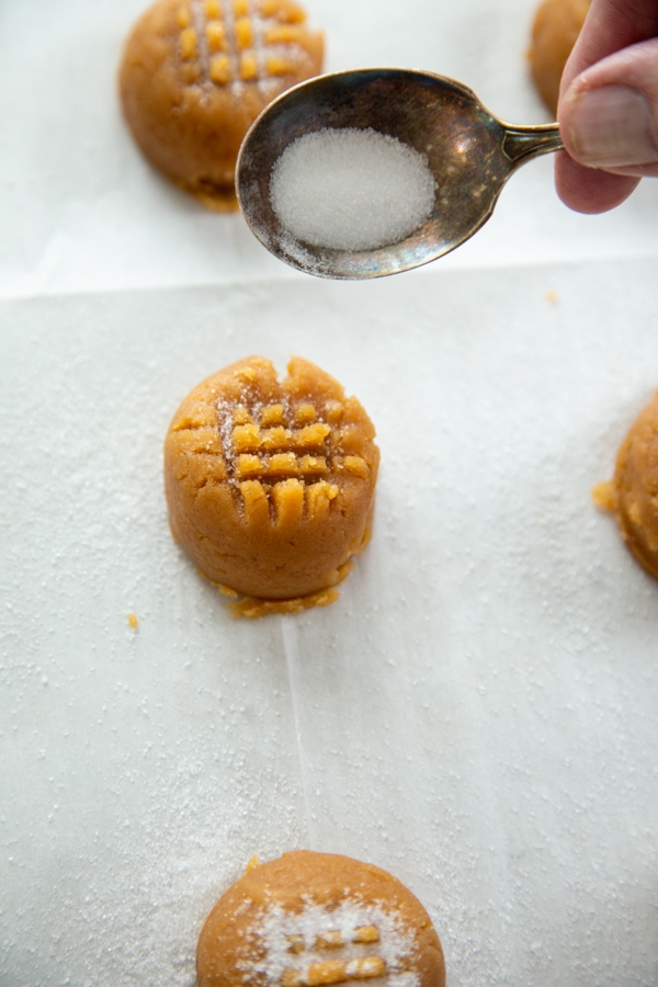 sugar being sprinkled on a cookie ball.