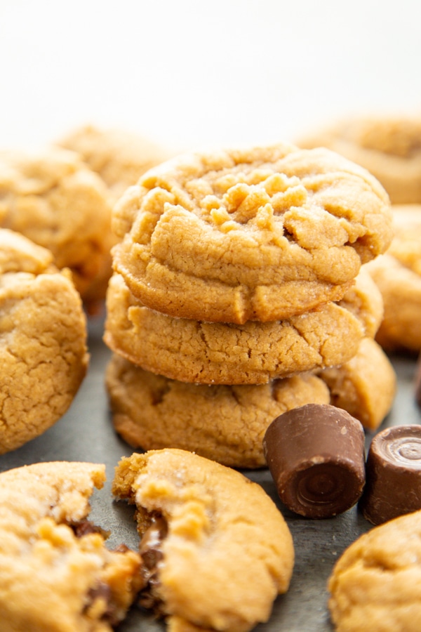a stack of stuffed peanut butter cookies with rolo candies next to it.