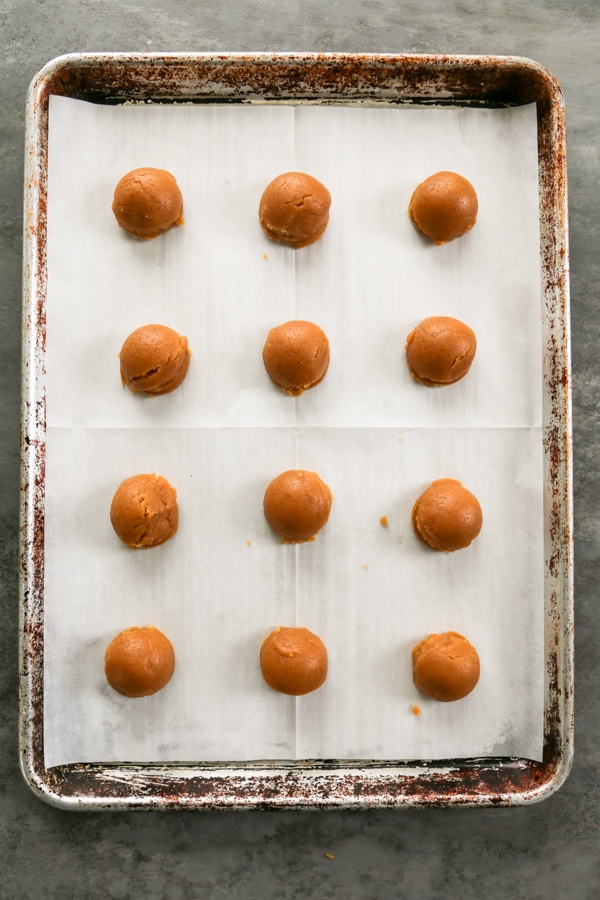 cookie dough balls on a baking sheet.