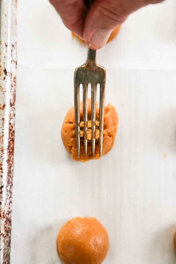 a fork making a hash mark on a dough ball.