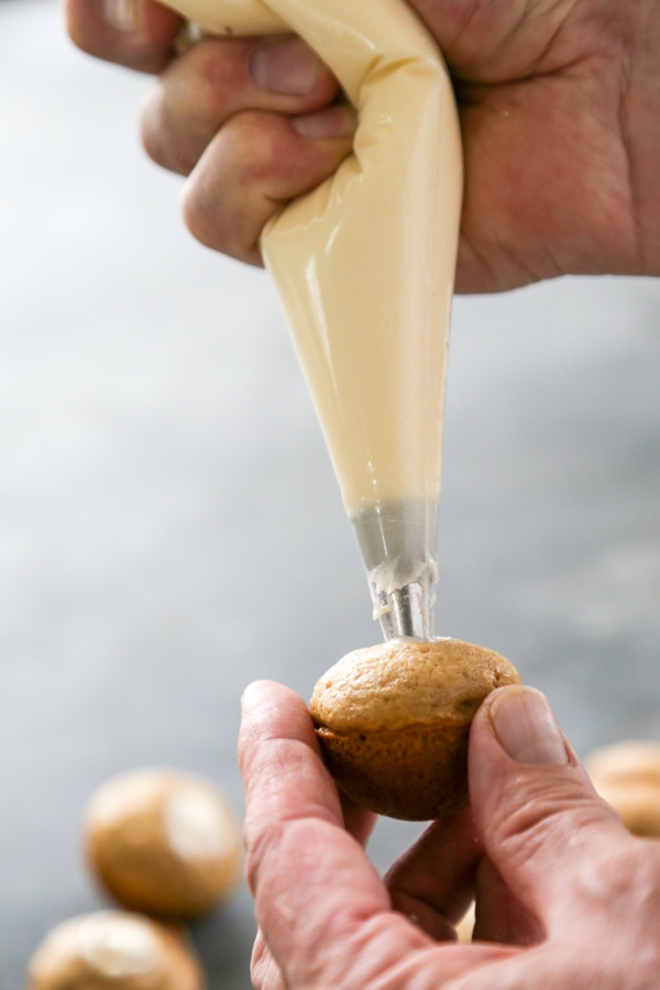 a donut hole being filled with frosting.