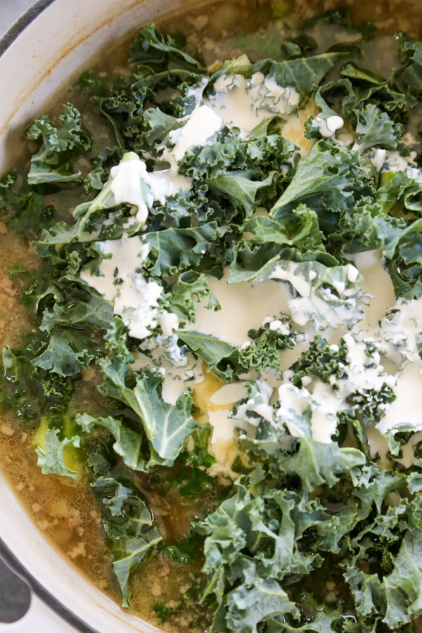 cream, kale, and cheese added to the pot.