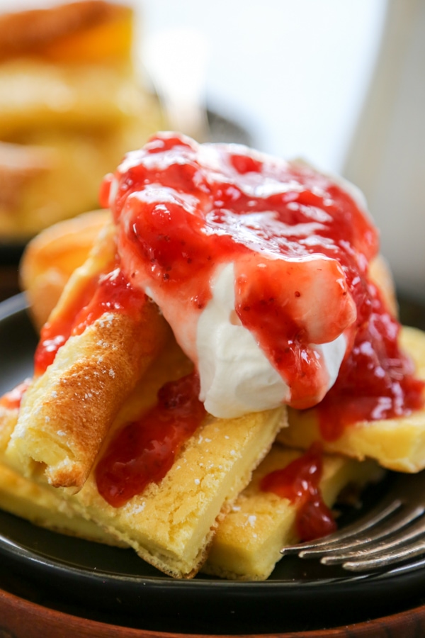 german pancakes topped with whipped cream and strawberries