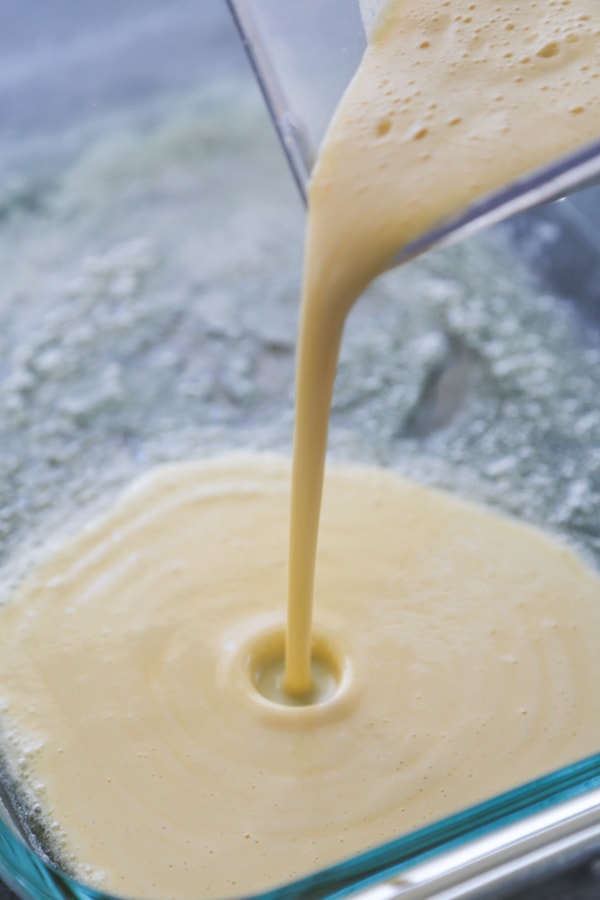 the batter being poured into the baking pan.