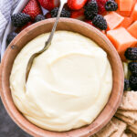 overhead shot of a bowl of fruit dip with fruit on the side.