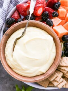 overhead shot of a bowl of fruit dip with fruit on the side.