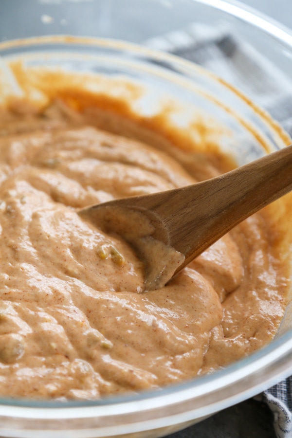 the sour cream and enchilada sauce mixture being mixed in a bowl.