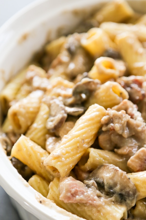 pasta, sauce, mushrooms, and bacon in the casserole dish.