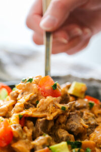 a close-up shot of the casserole getting scooped up with a spoon.