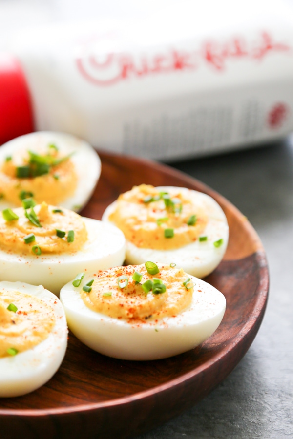 deviled eggs on a plate with chick-fil-a sauce bottle behind it.