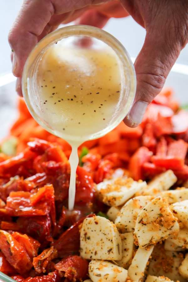 dressing being poured over the salad.