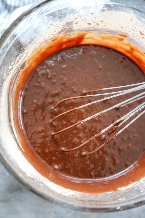 melted chocolate in a bowl with a whisk.