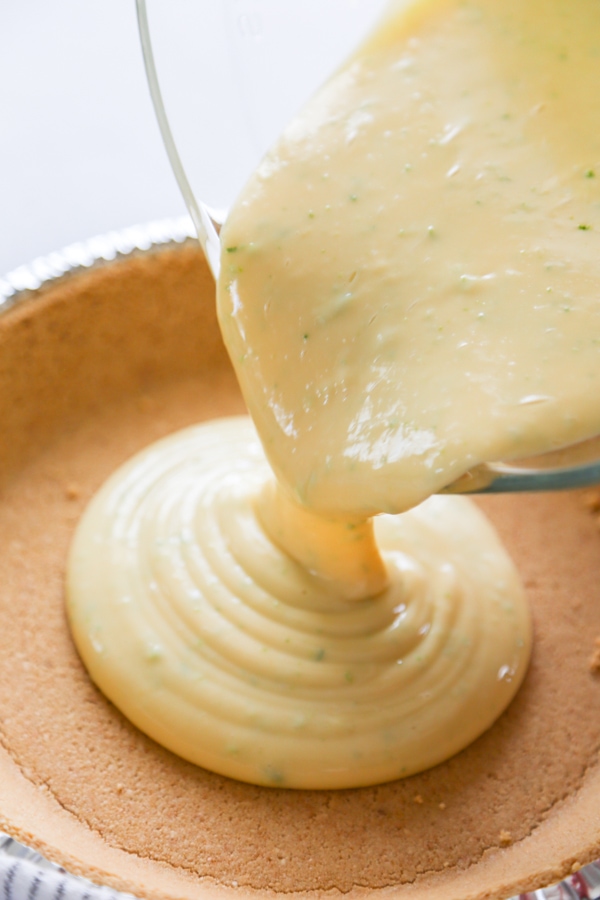 the pie filling being poured into the crust.