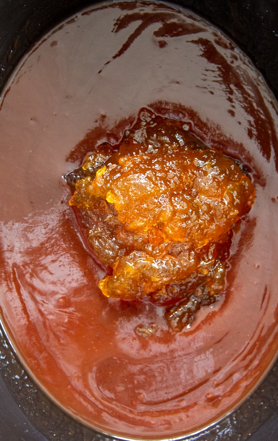 BBQ sauce and peach preserves in black crock pot