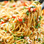 garlic noodles in pan with tongs