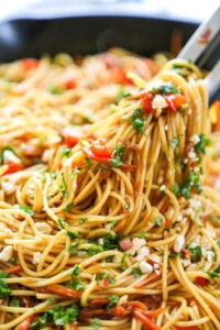 garlic noodles in pan with tongs