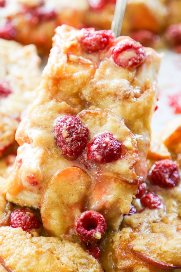 Easy Raspberry & Peach Danish filled with peaches & raspberries with a cream cheese drizzle. All the elements of a delicious pastry with fewer simple steps. close-up shot of a Danish.