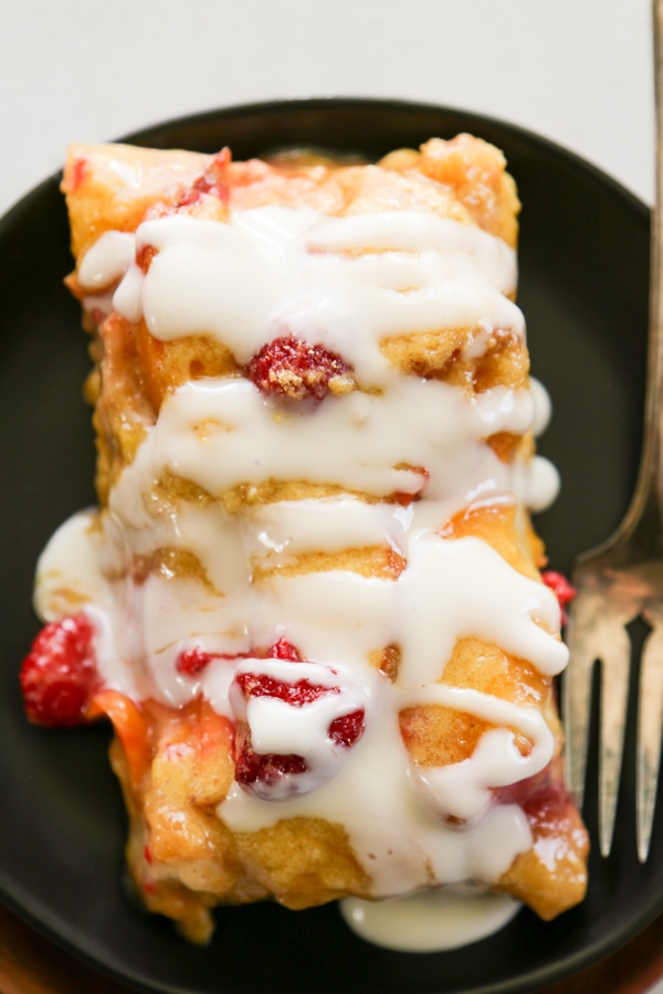a slice of peach Danish topped with cream cheese icing.