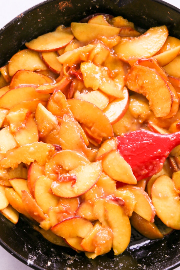 the cooked peaches in a pan.