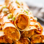 close up shot taquitos stacked on plate