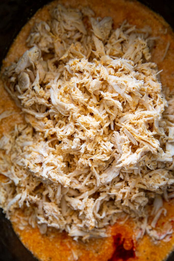 overhead shot of cooked shredded chicken in sauce