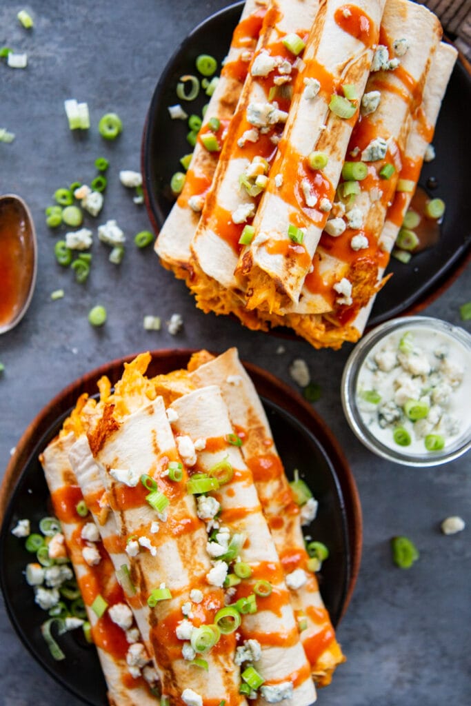 overhead shot of buffalo chicken taquitos with blue cheese and sauce