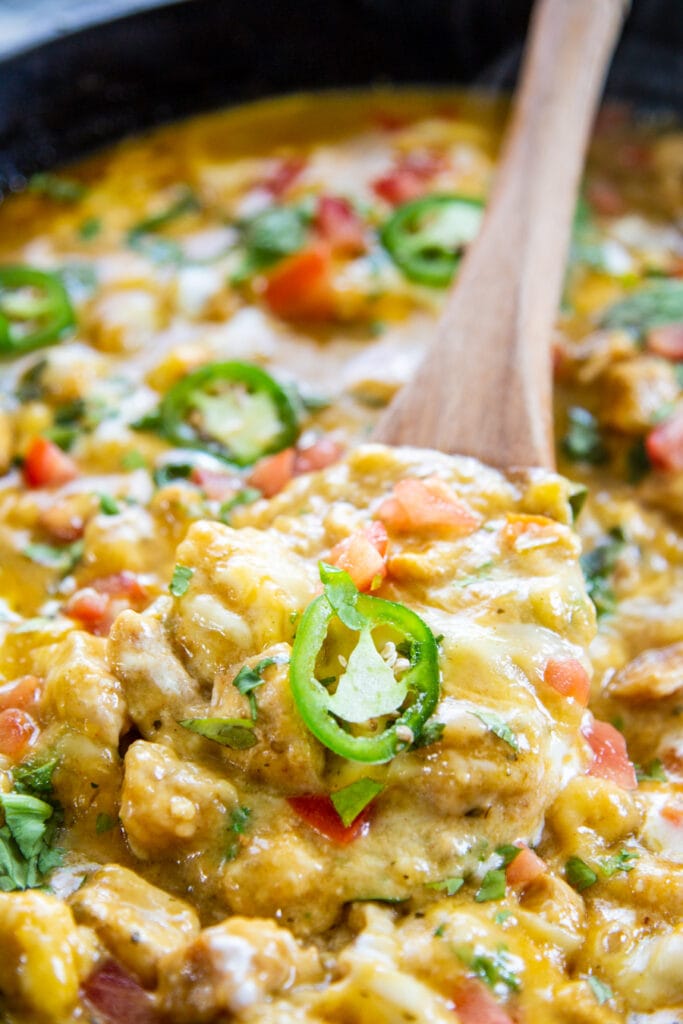 skillet chicken chile verde with wooden spoon