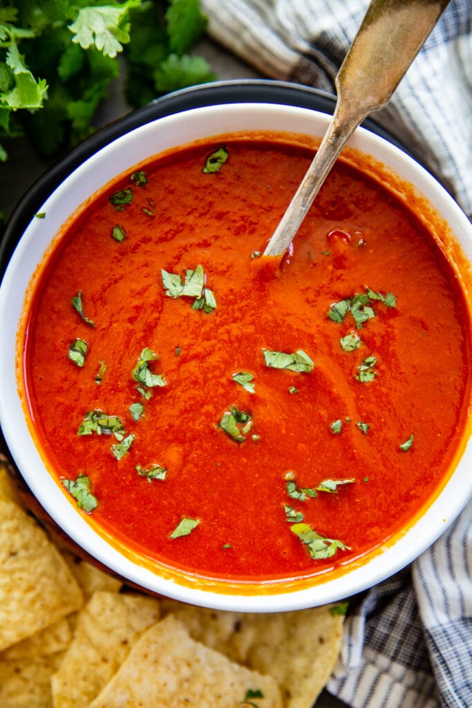 red chile sauce in bowl overhead shot with cilantro