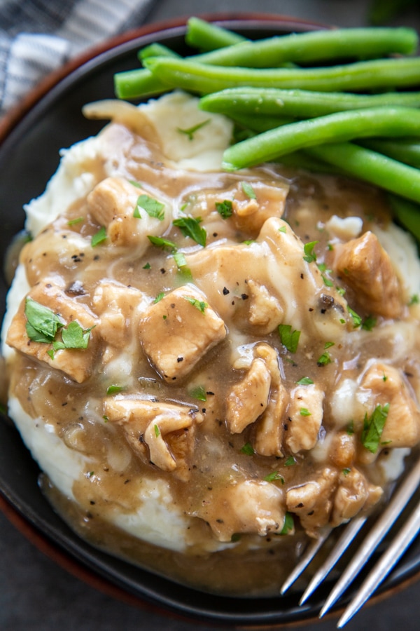 overhead shot of plate of french onion chicken over mashed potatoes and green beans