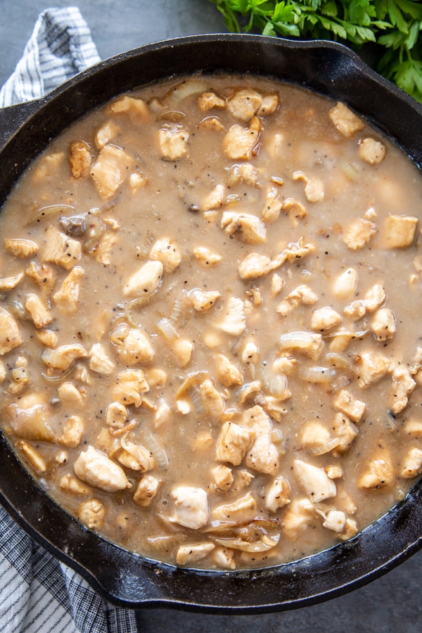 overhead shot of chicken in skillet with seasonings and soup