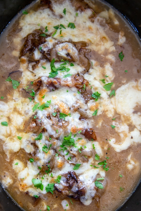 overhead shot pork chops in slow cooker topped with melted cheese