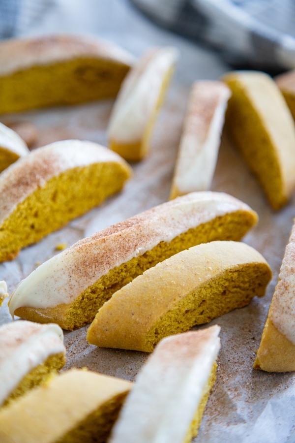 pumpkin biscotti on parchment paper some dipped in white chocolate and some plain