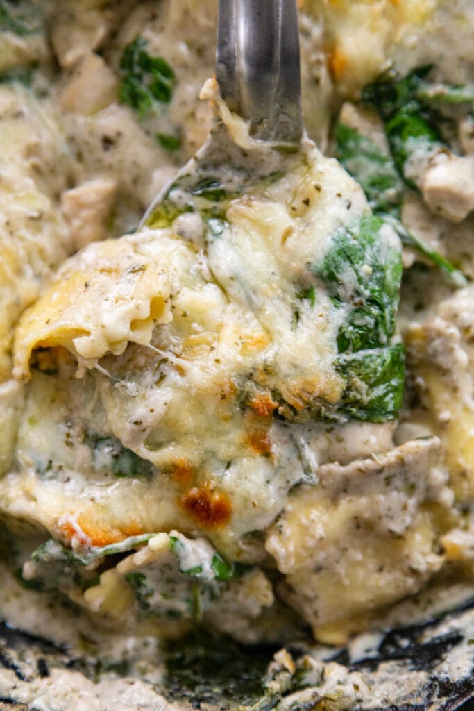 spoonful of pesto ravioli on plate with fork