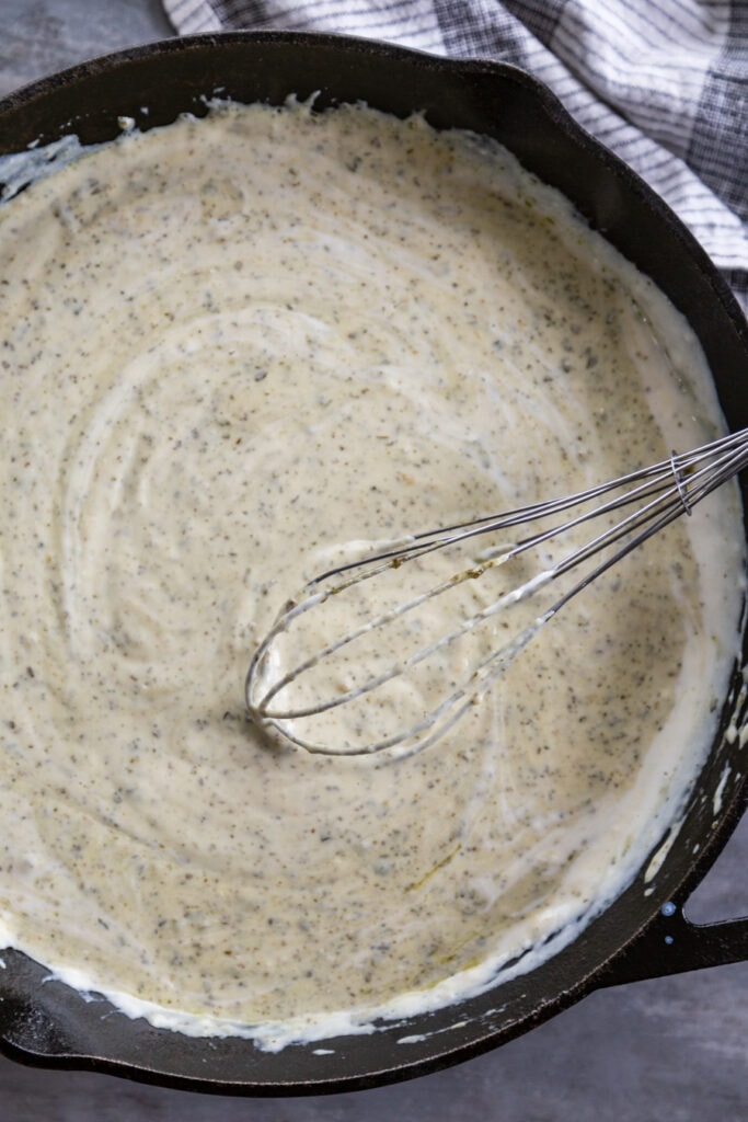 overhead shot of skillet with creamy pesto sauce