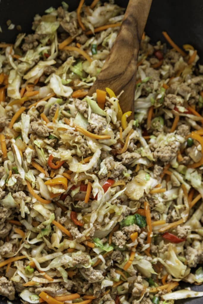 overhead shot of egg roll in a bowl in skillet