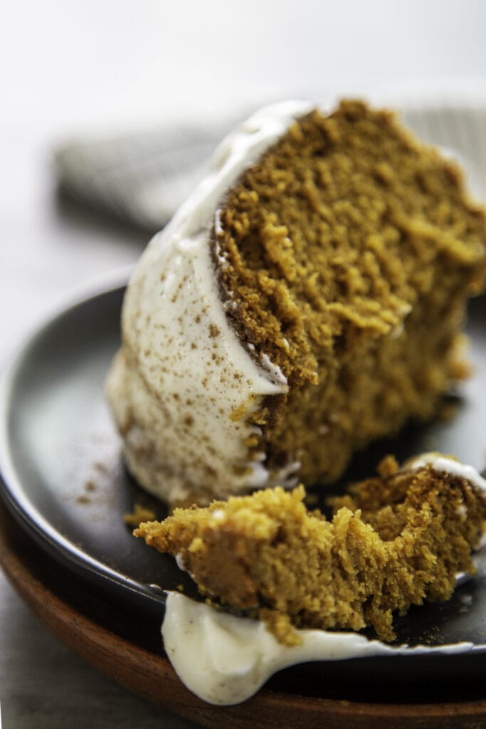 pumpkin bundt cake bite on black plate with fork